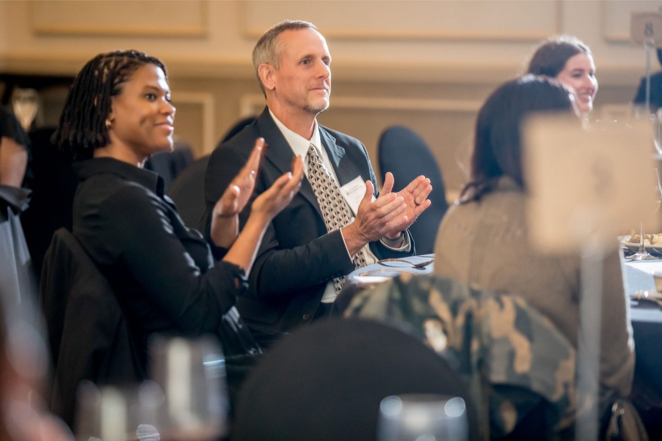 Attendees applauding during a conference session