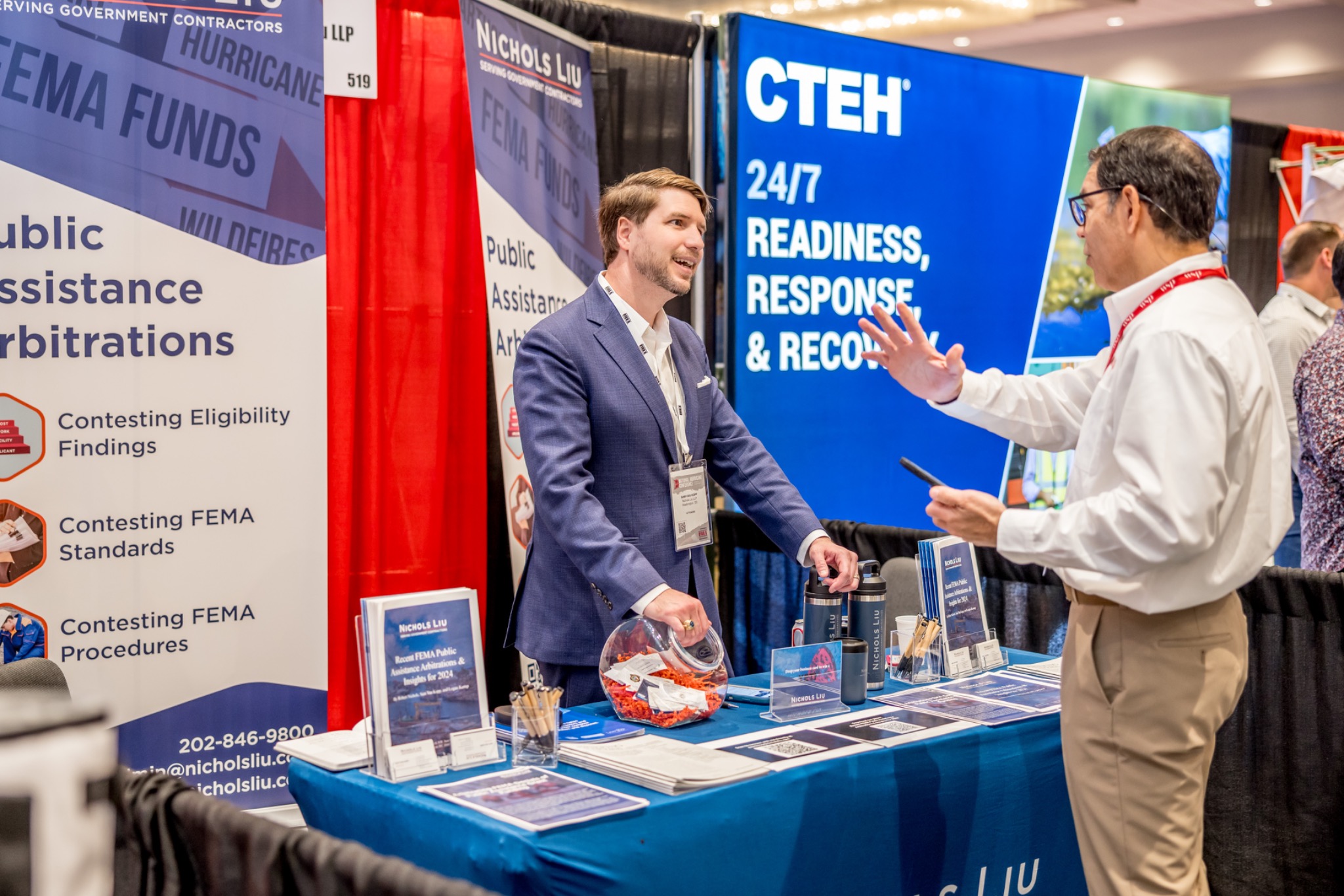 Two conference attendees talking at an exhibitor booth